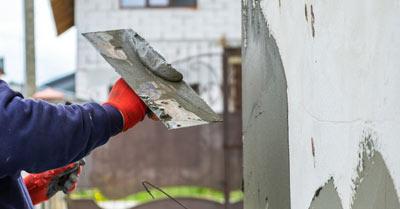 A man rendering a wall